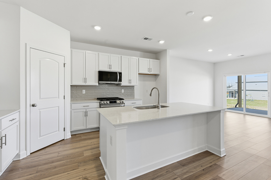 A kitchen with white cabinets.