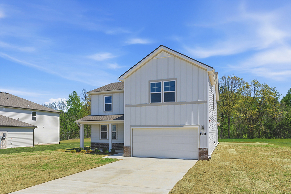 A house with a garage with Rockingham Meeting House in the background.