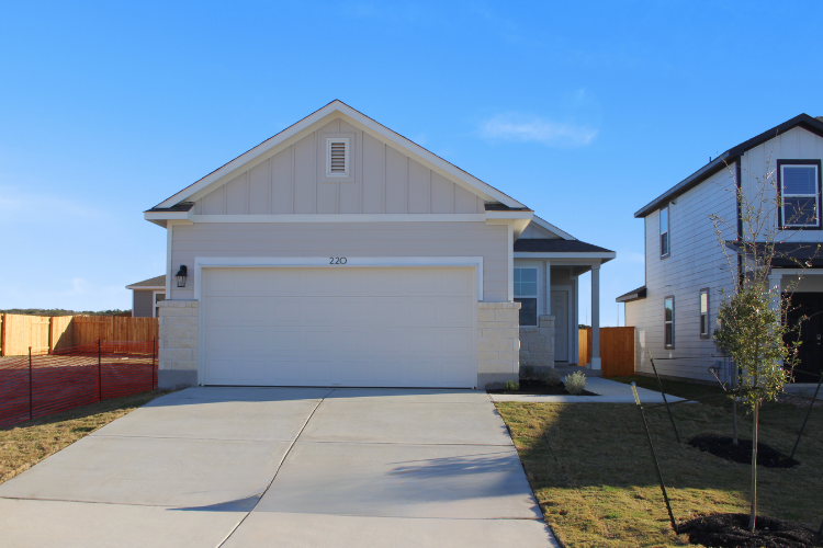 A white garage with a fence.