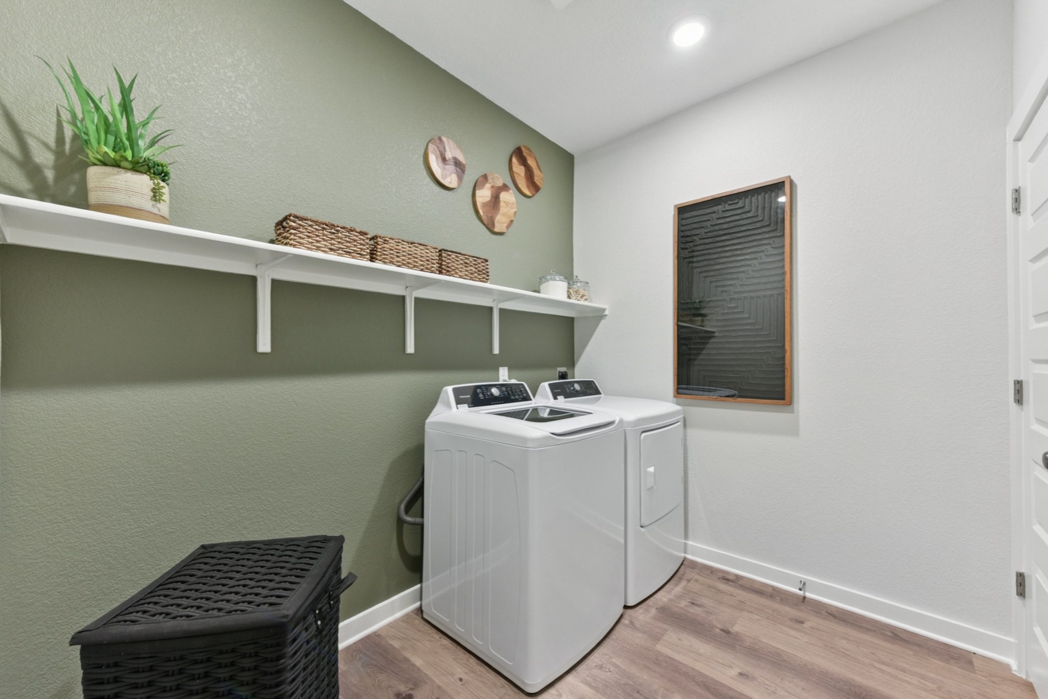 A room with a shelf and a table with a plant on it.