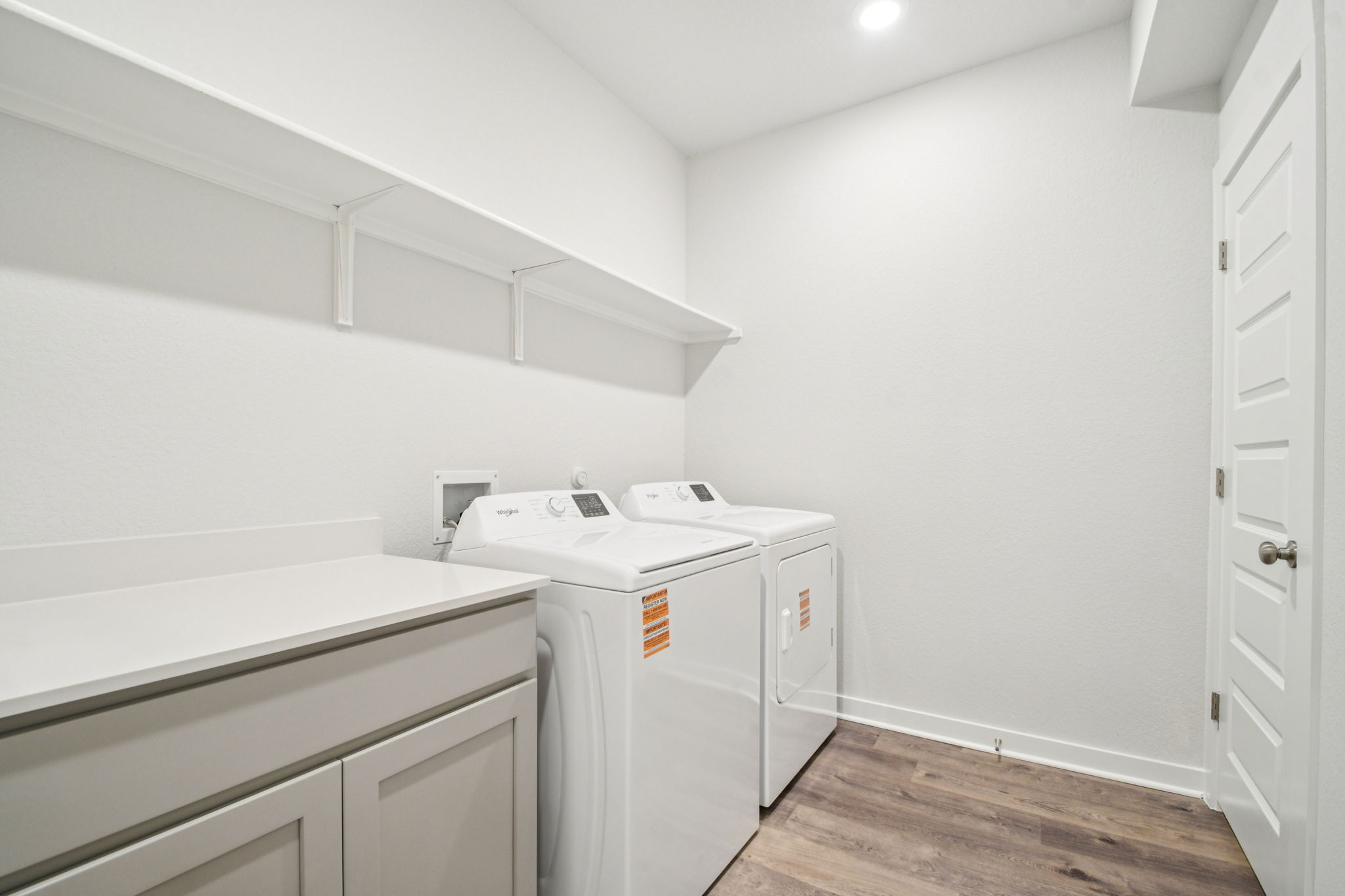 A room with white cabinets and a washing machine.