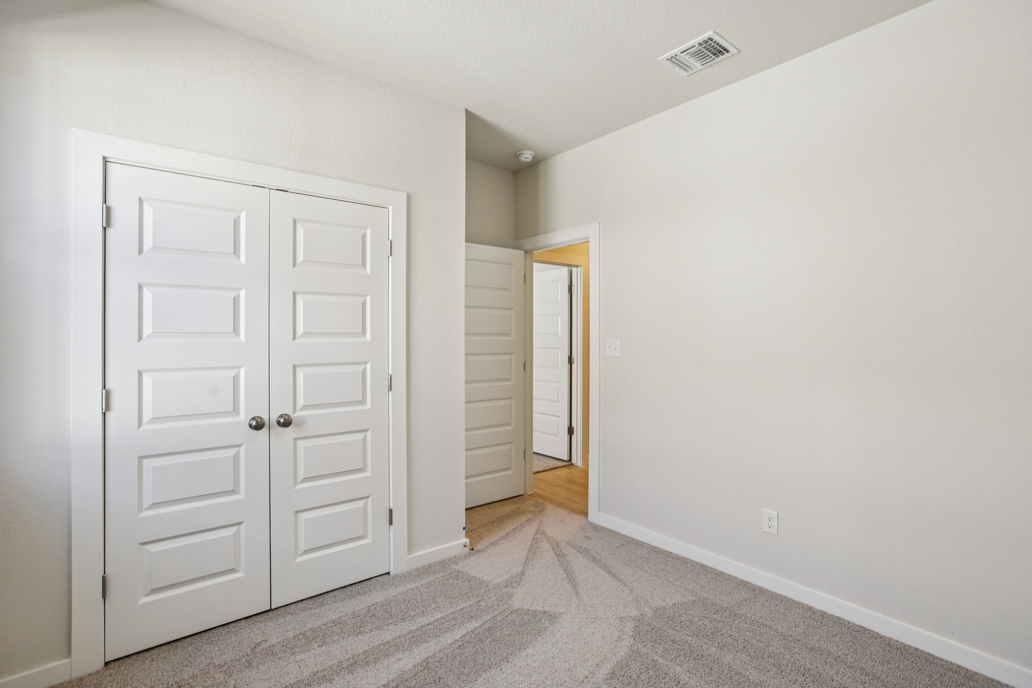 A hallway with white doors.