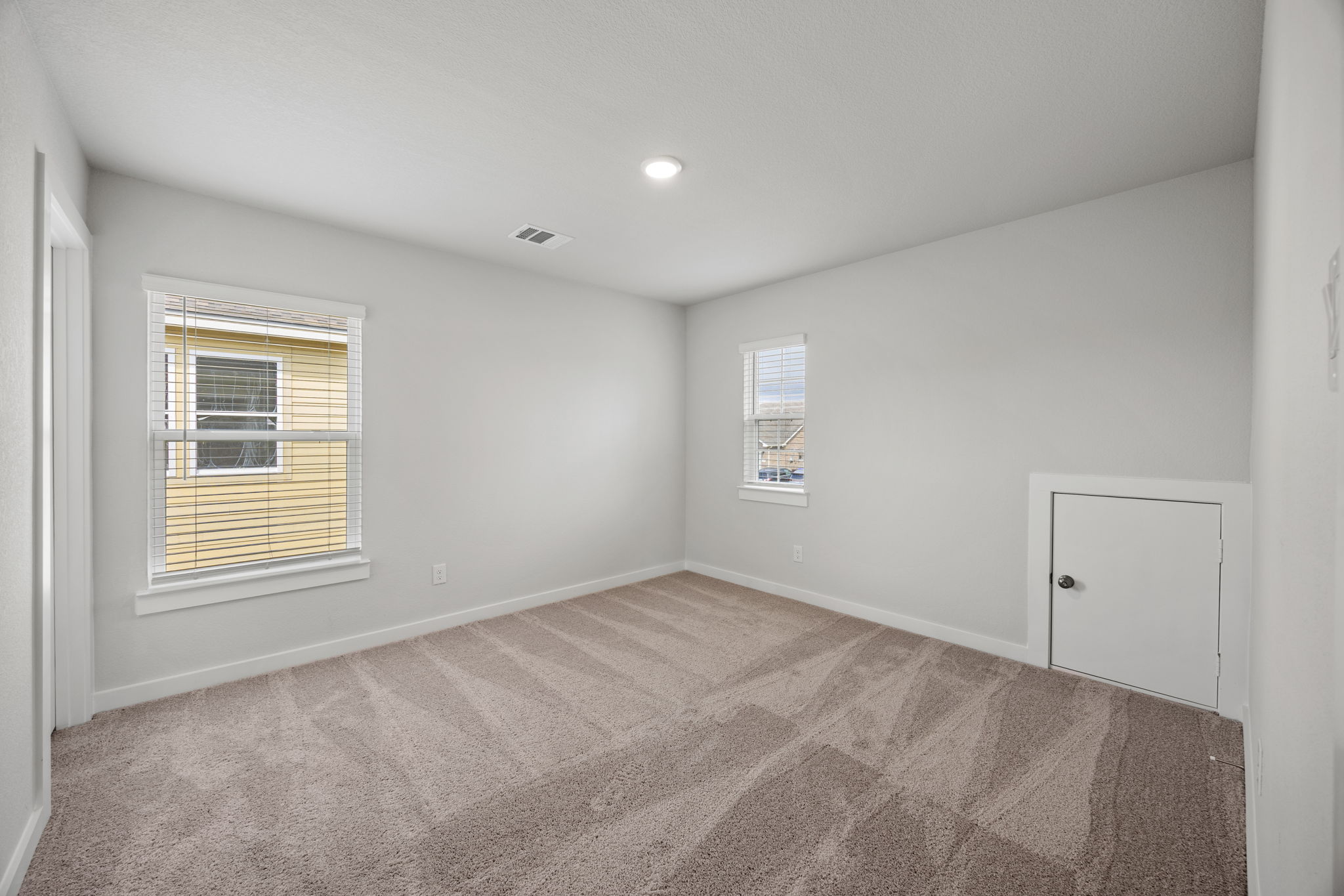 A room with a carpet and a window.