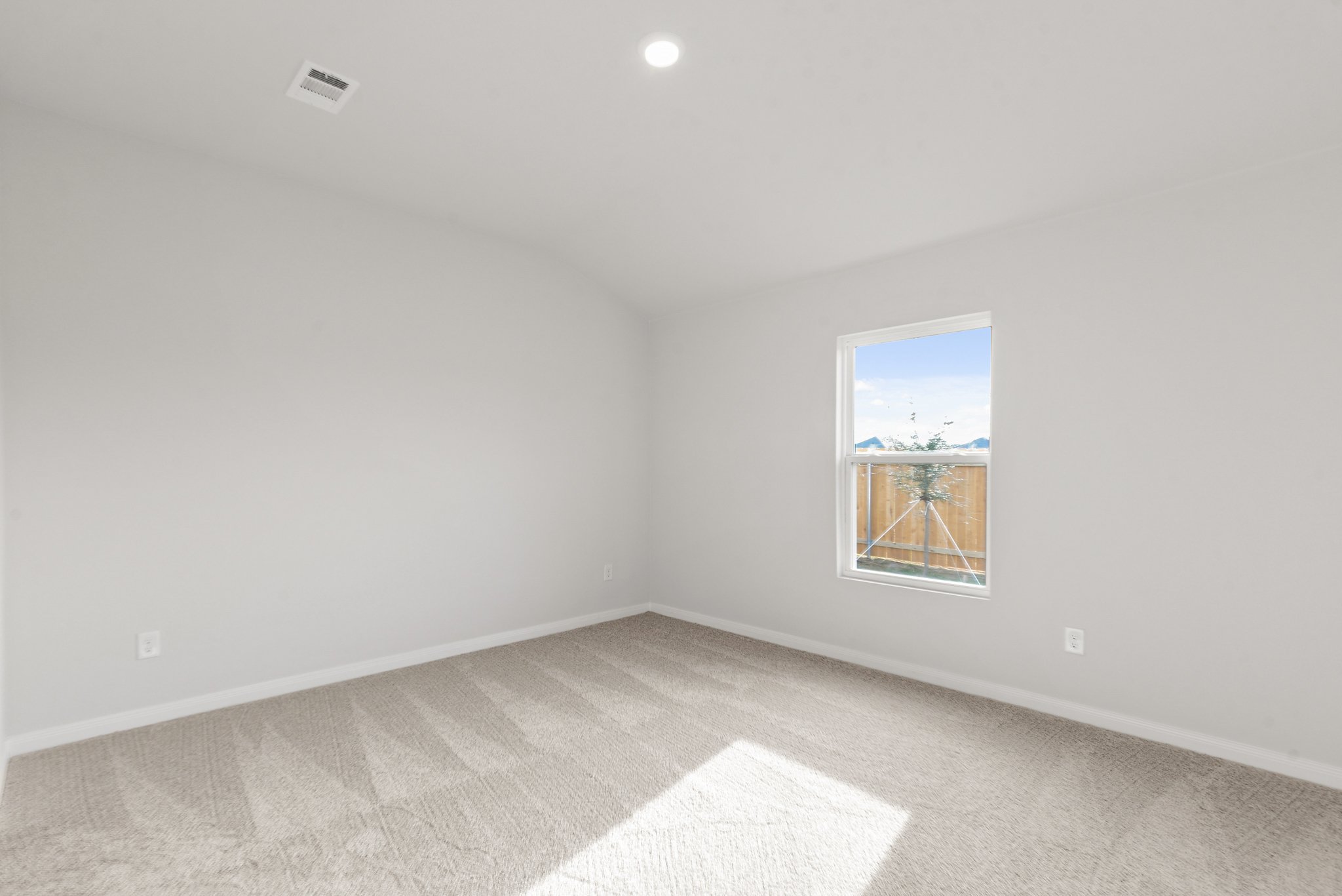 A room with a window and a rug.