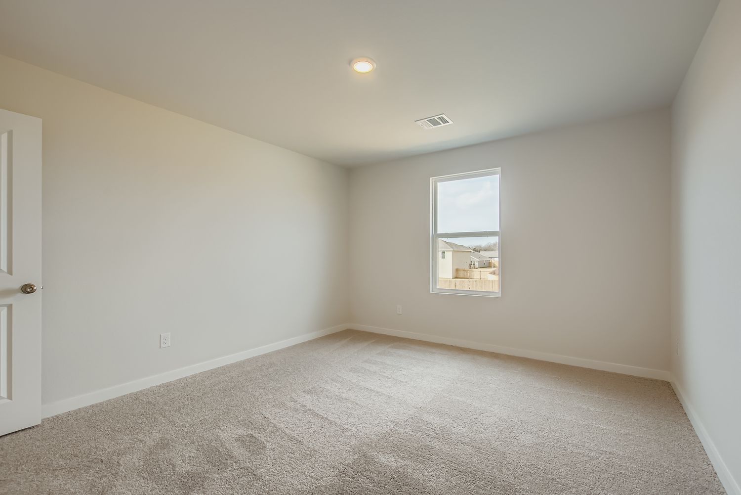 A room with a carpet and a door.