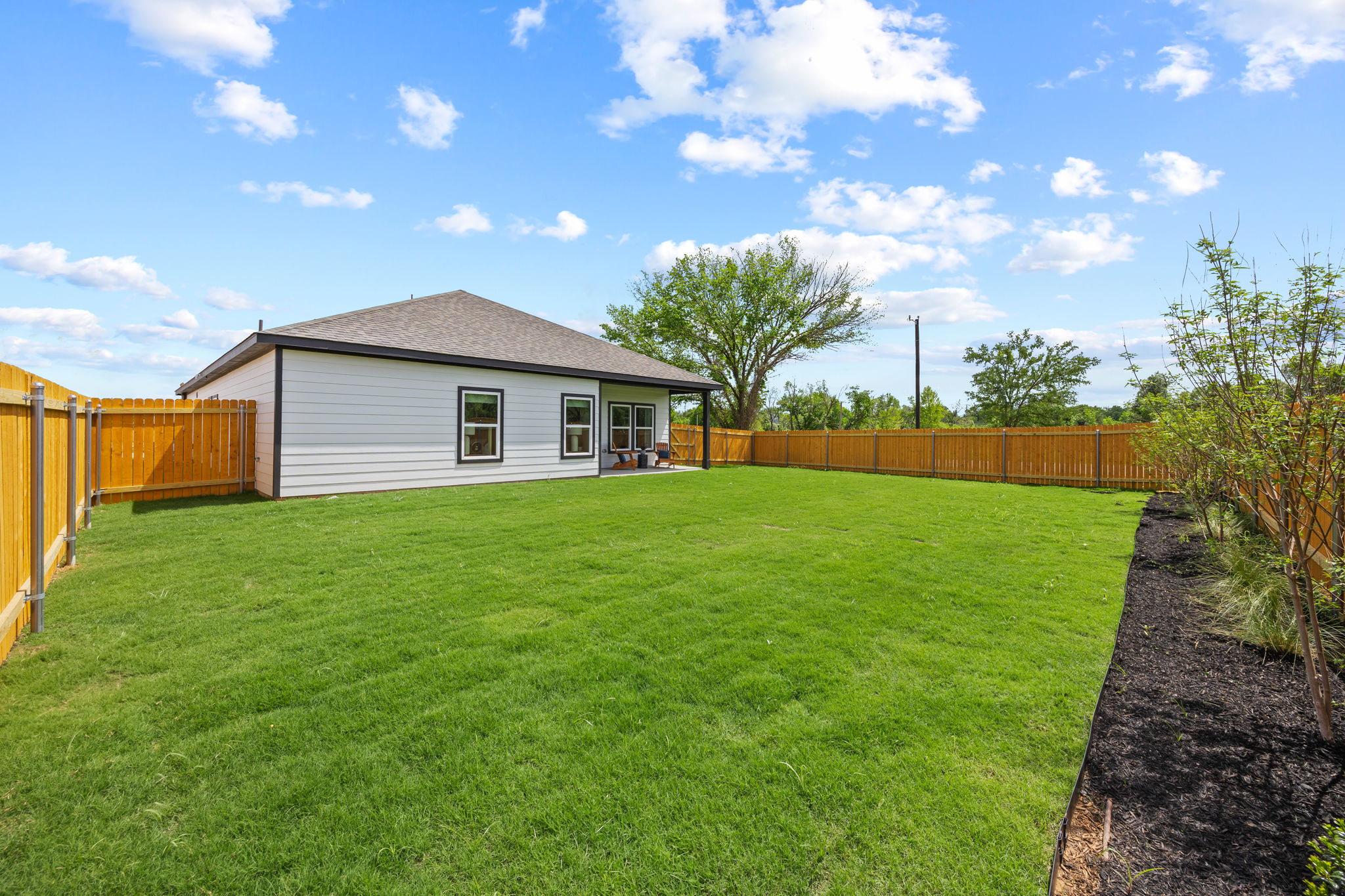 A house with a fence and trees.