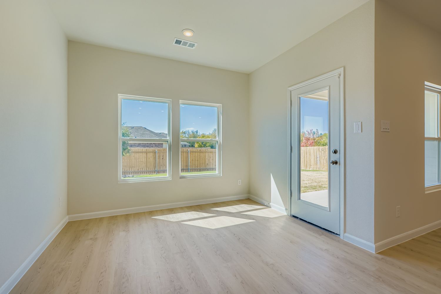A room with a wood floor and a wood floor with a door open.
