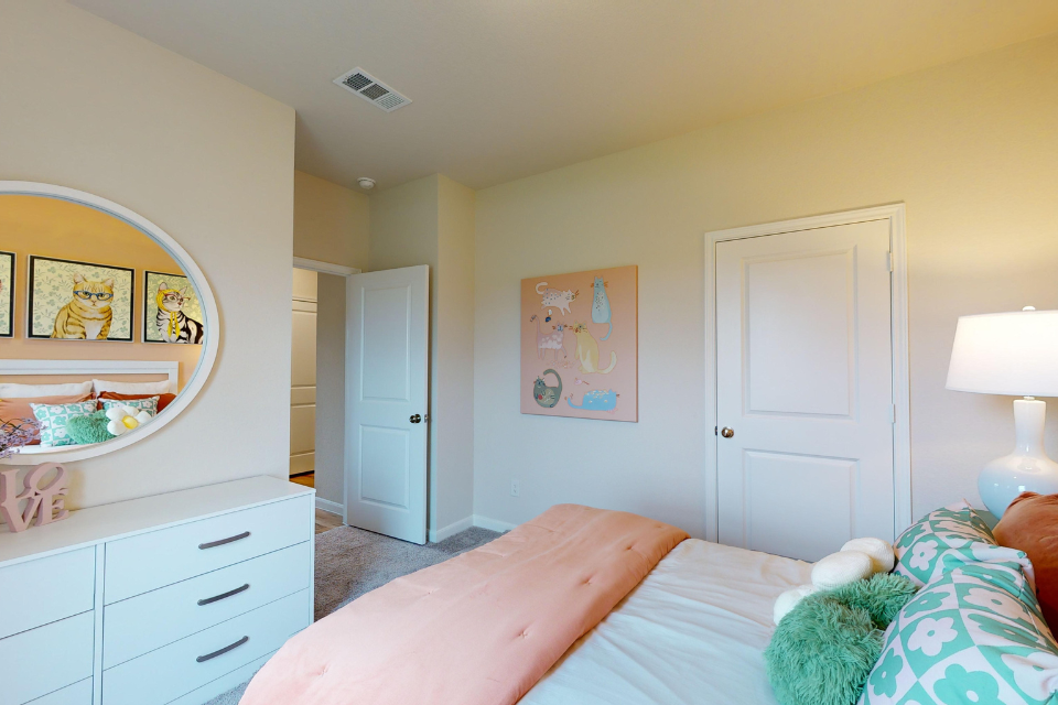 A bedroom with a bed and a lamp.