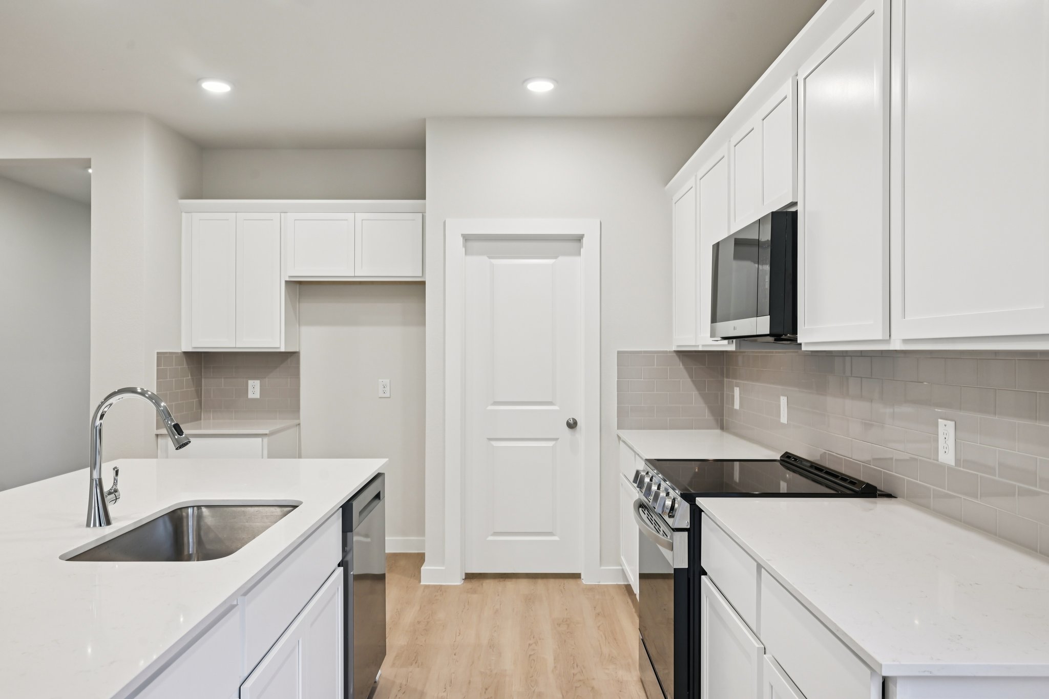 A kitchen with white cabinets.