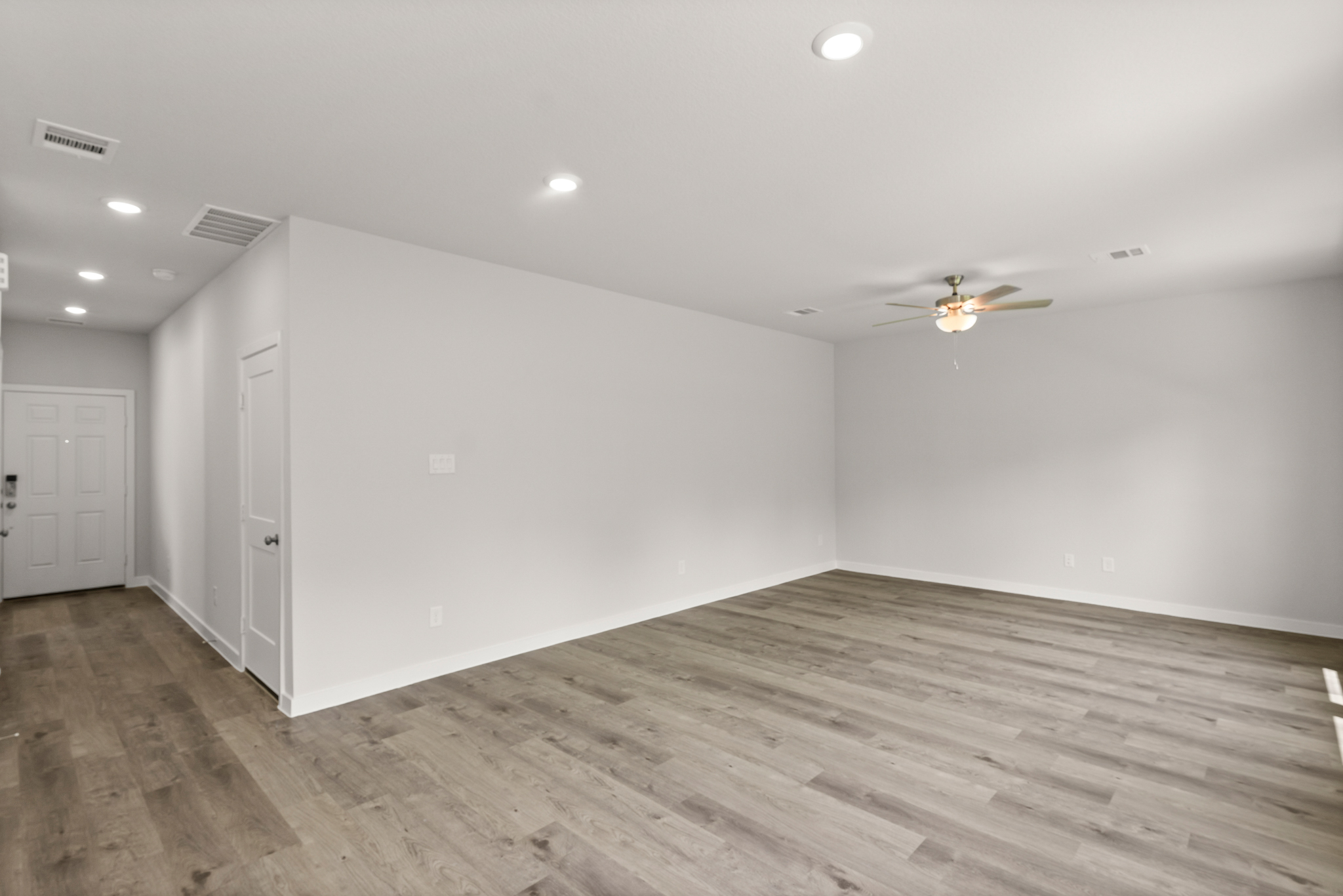 A room with a wood floor and white walls.