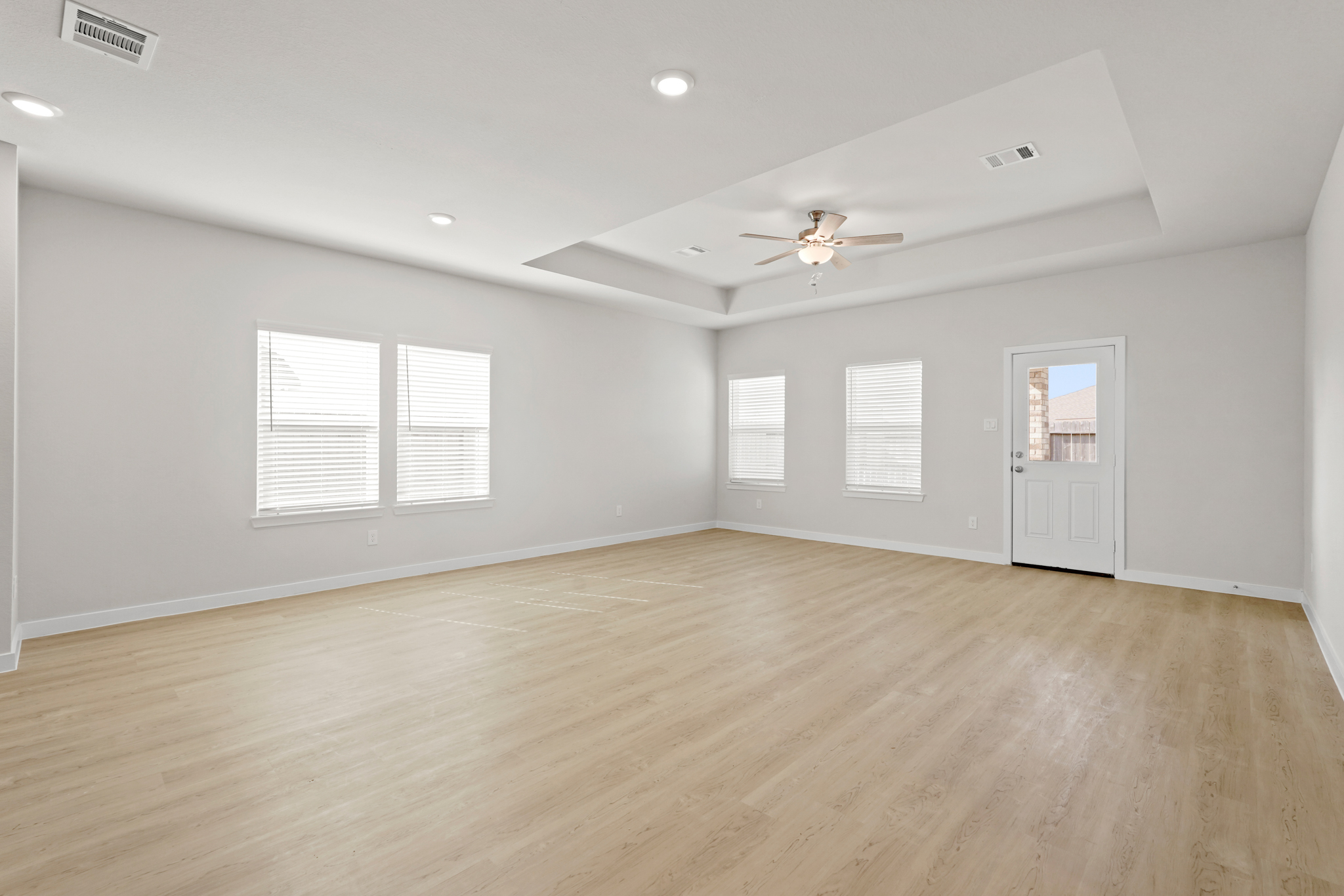 A room with a wood floor and a ceiling fan.