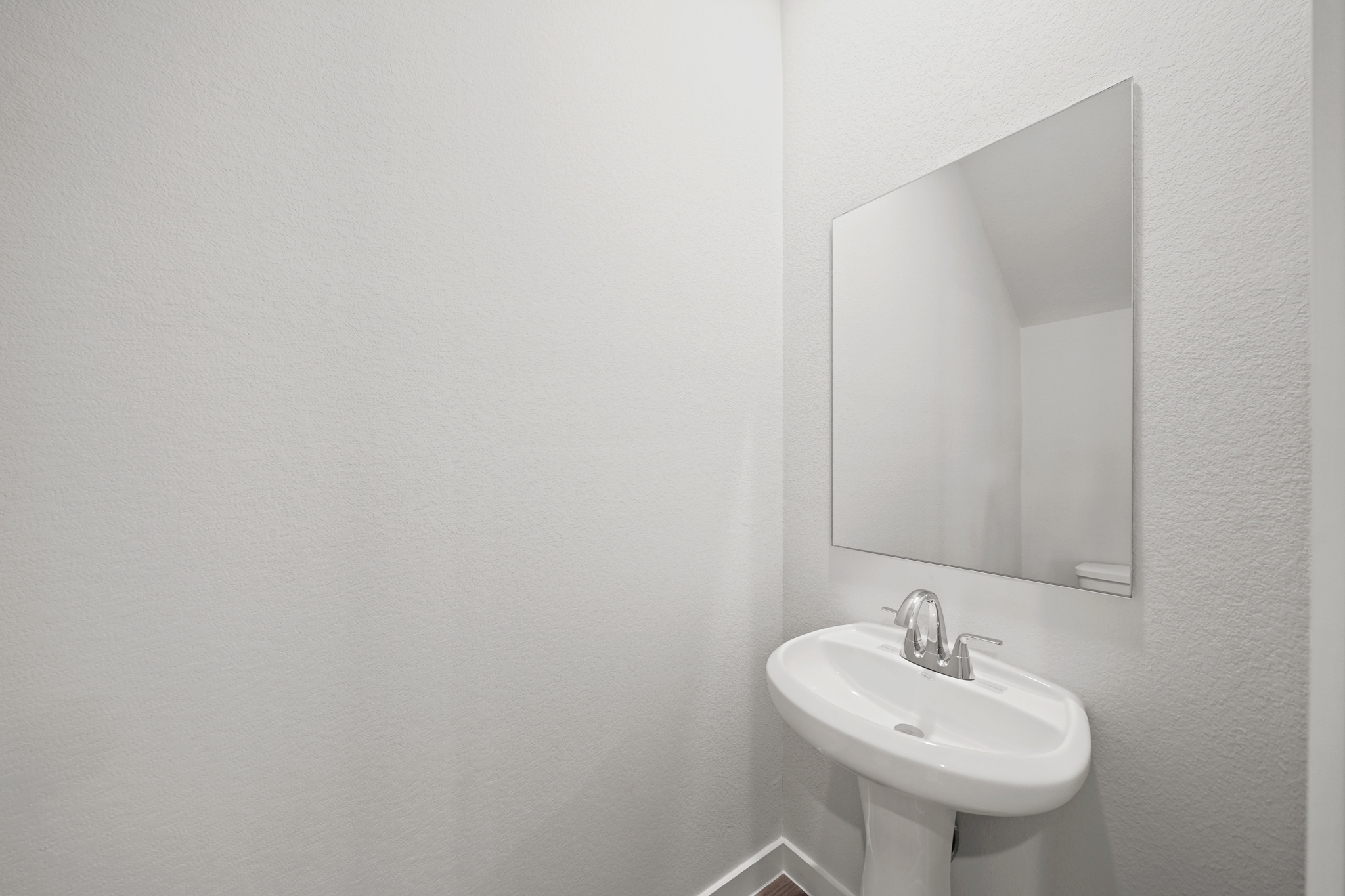 A bathroom with a round mirror.
