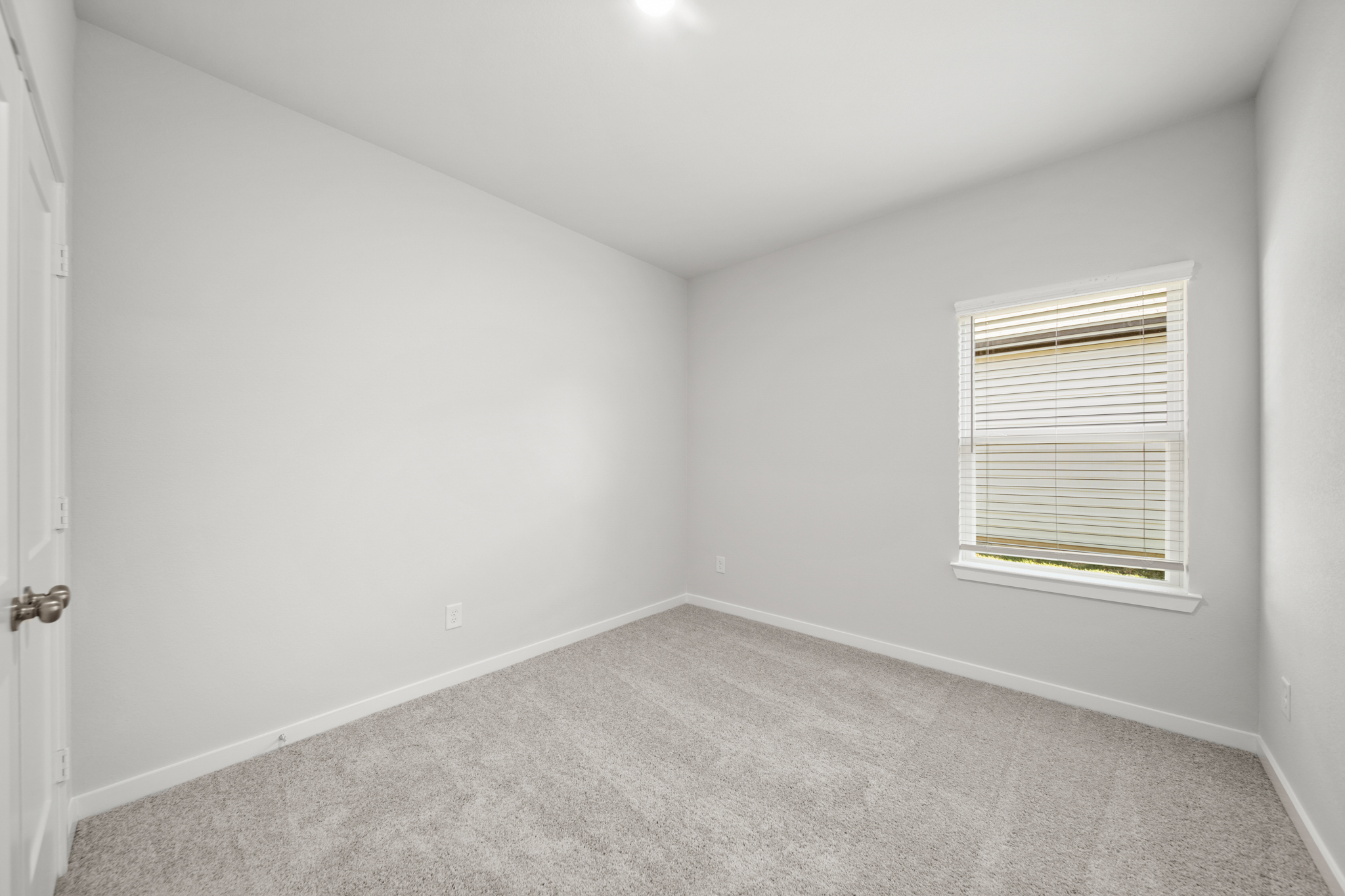 A room with a window and a carpet.