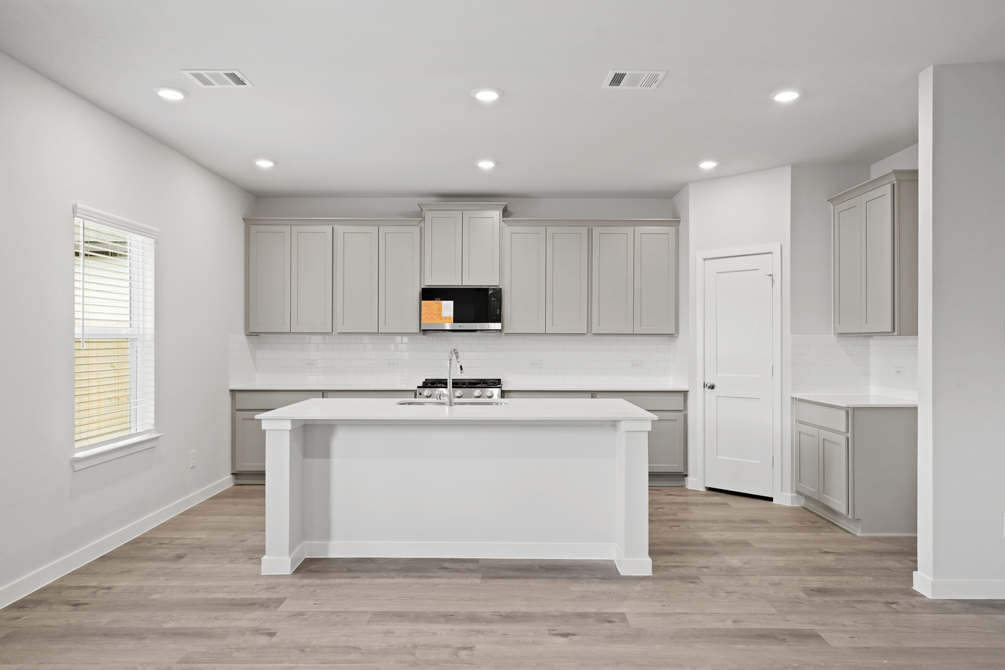 A kitchen with white cabinets.
