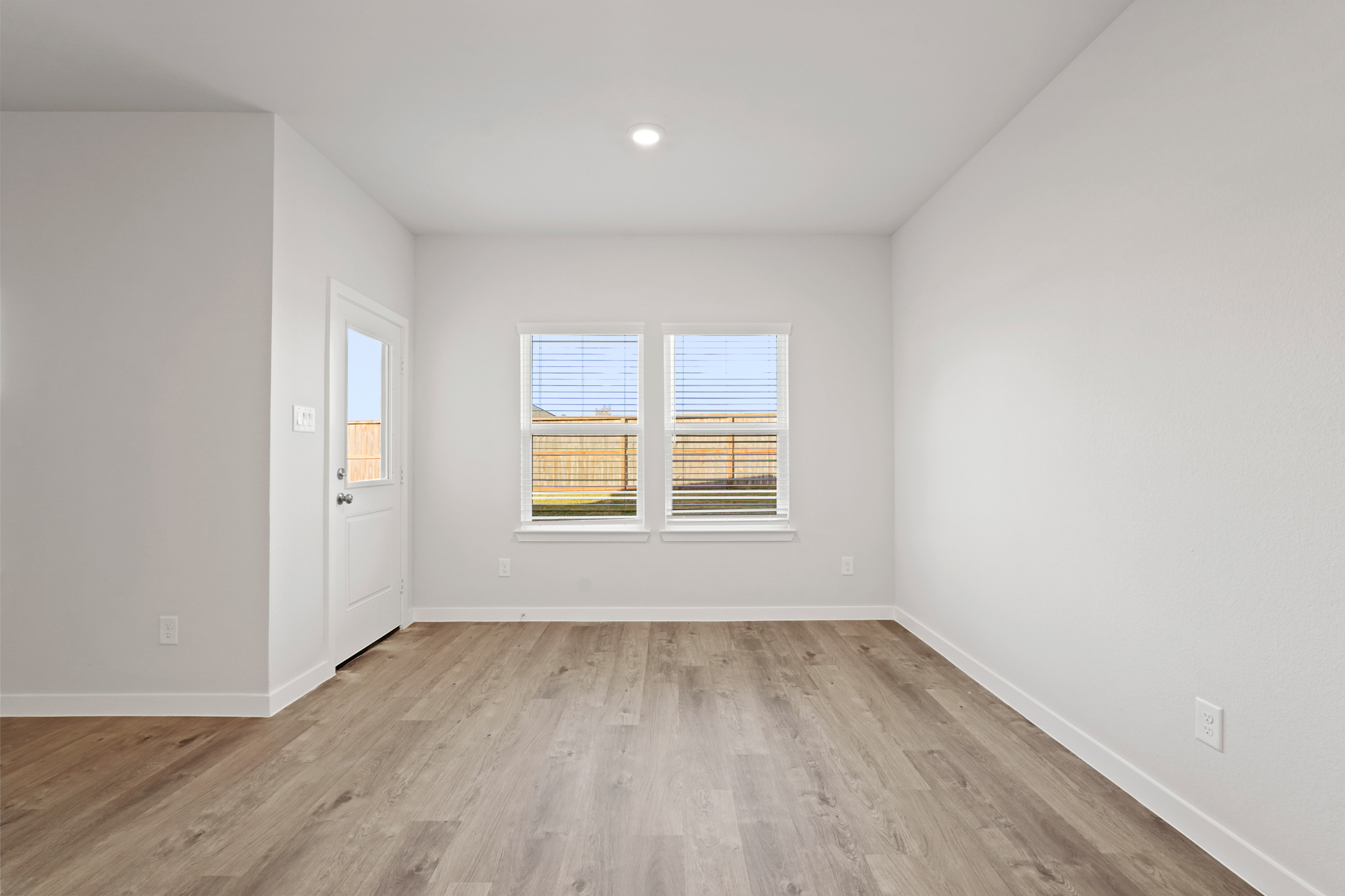 A room with a wood floor and windows.