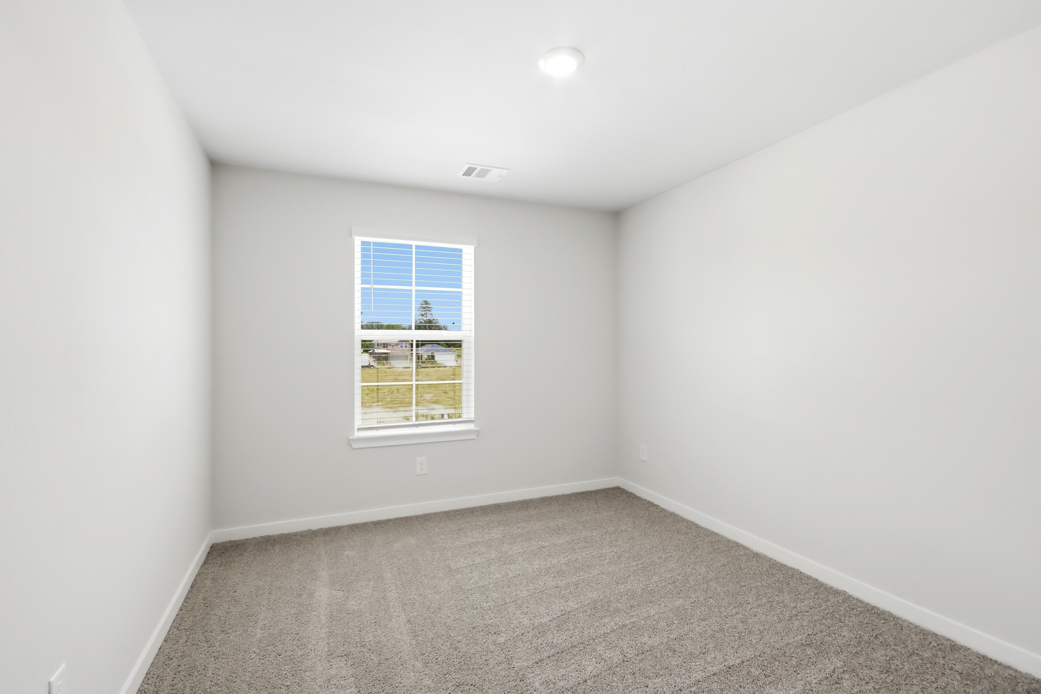 A room with a window and carpet.