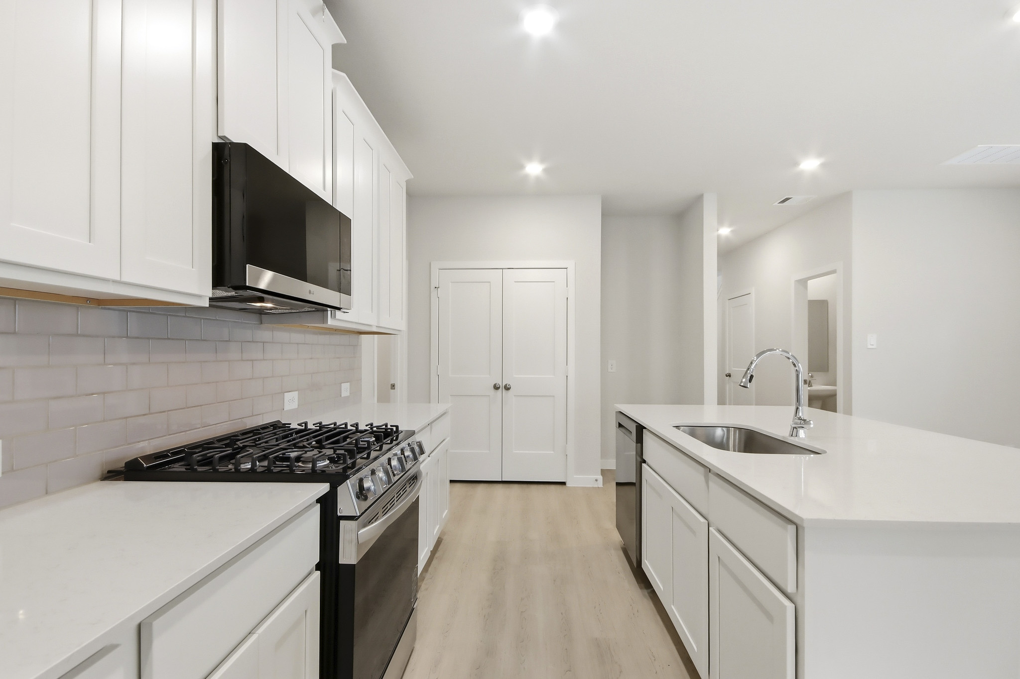 A kitchen with white cabinets.
