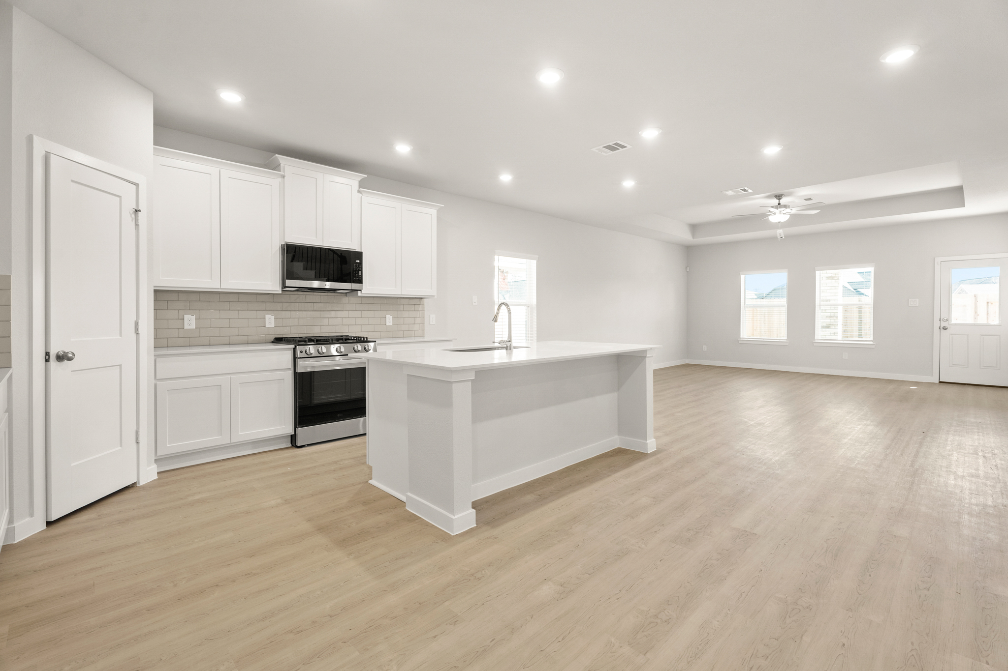 A kitchen with white cabinets.