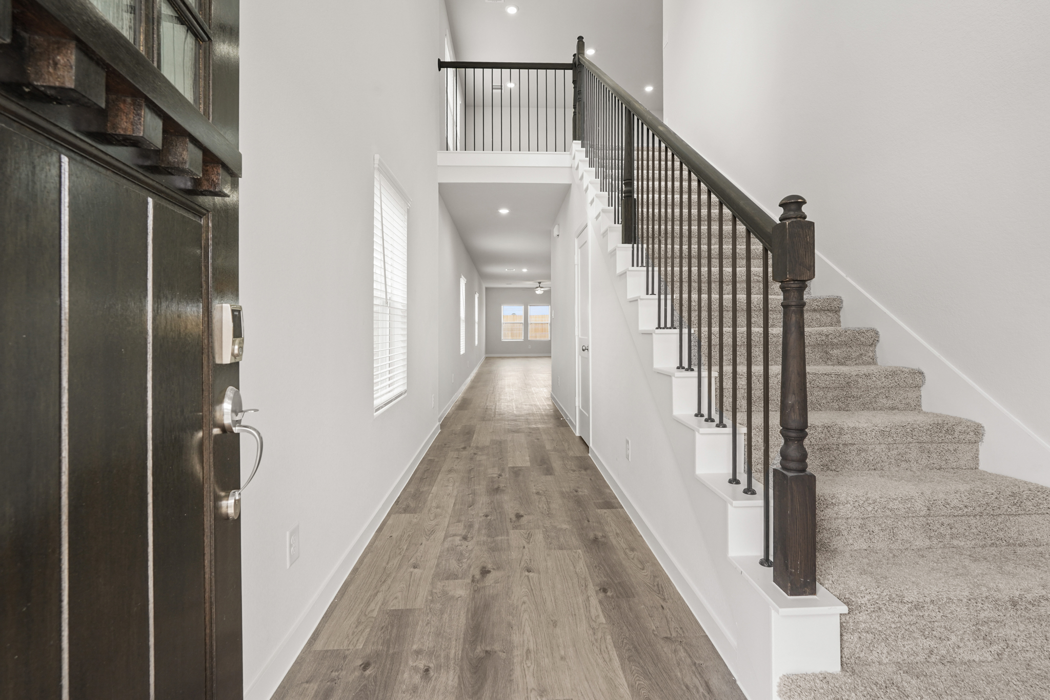A hallway with a wood floor and white walls.