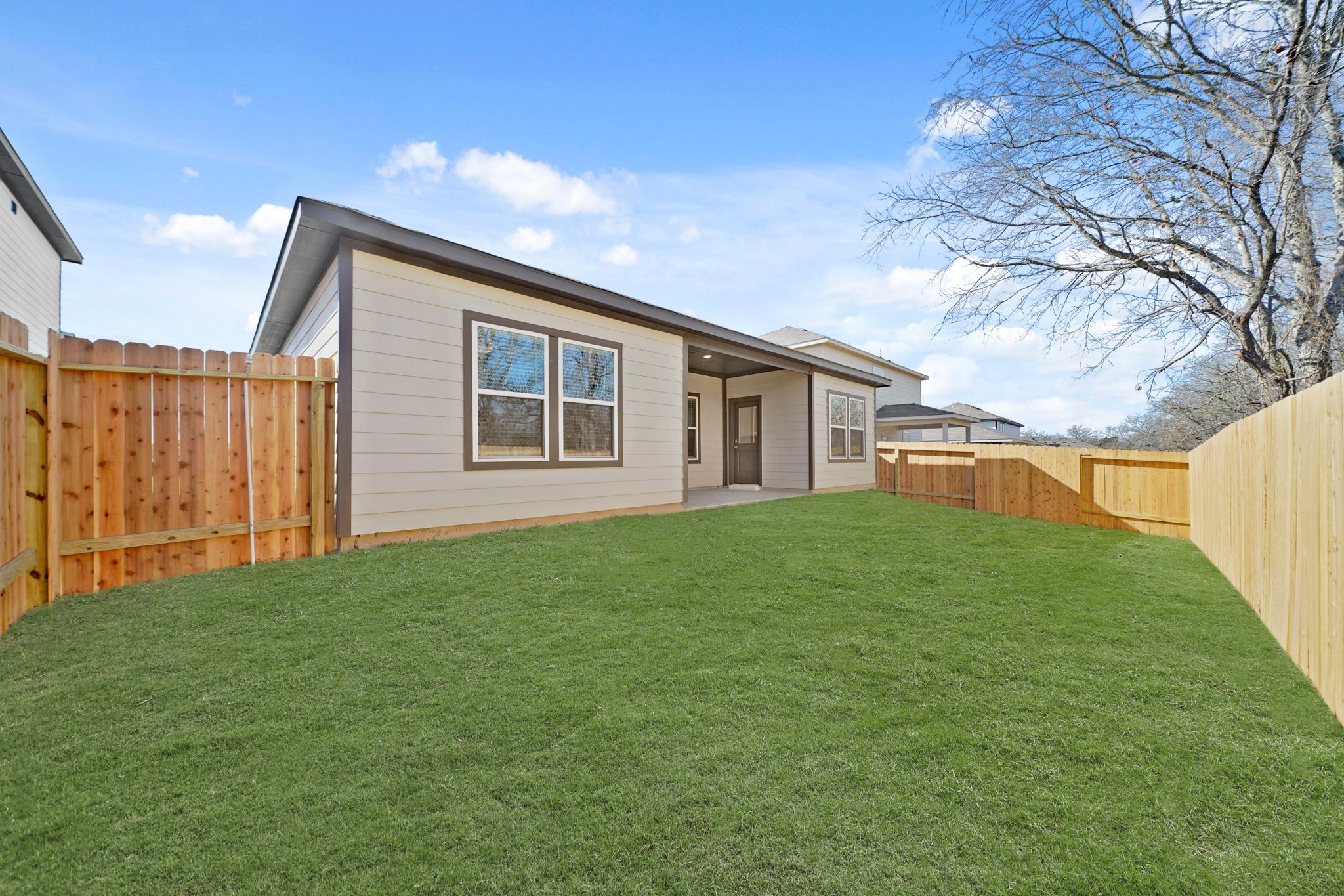 A house with a fence and grass.