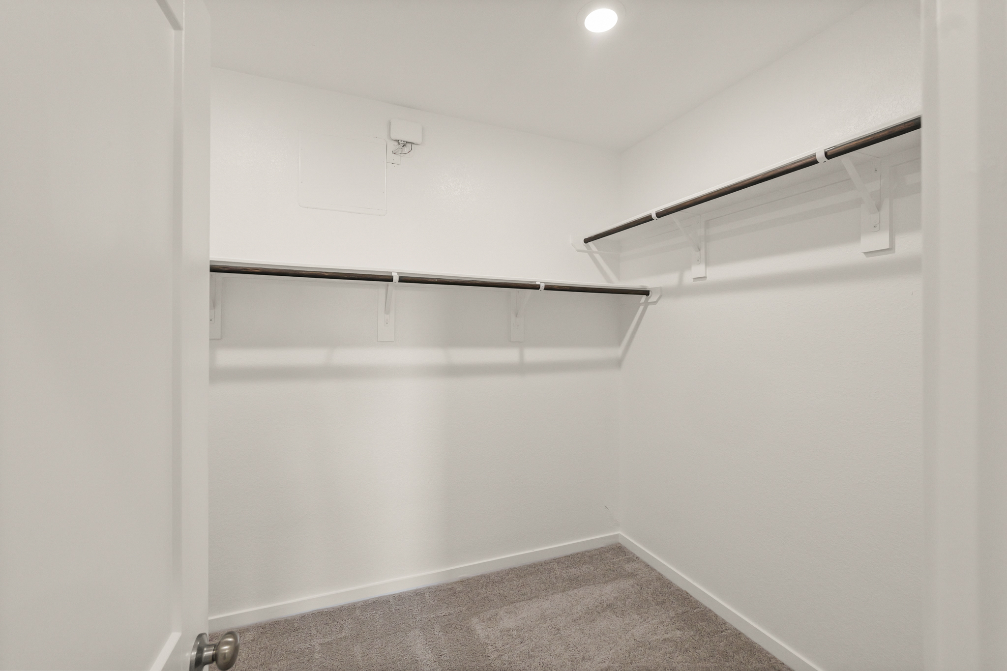 A white wall with a metal bar.