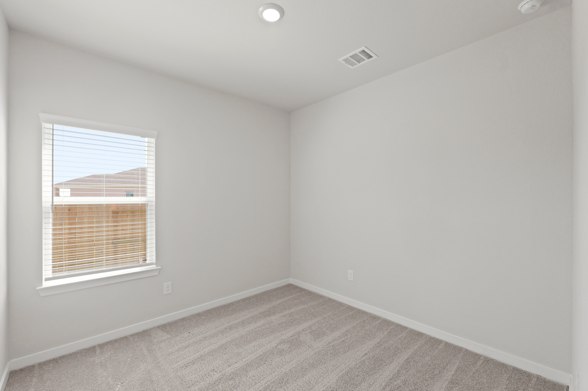 A room with a window and a carpet.