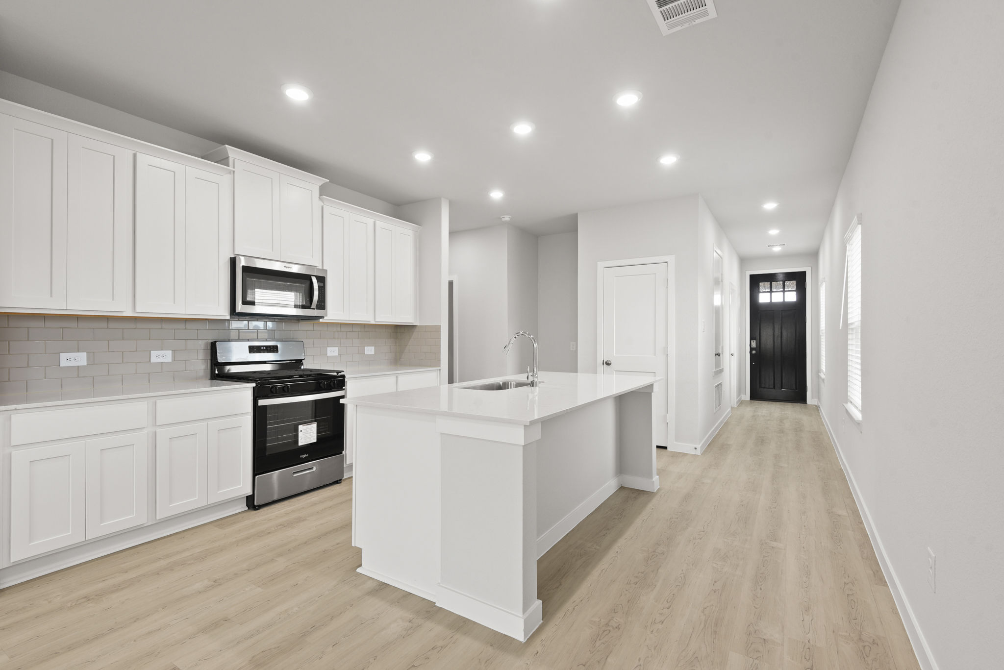 A kitchen with white cabinets.
