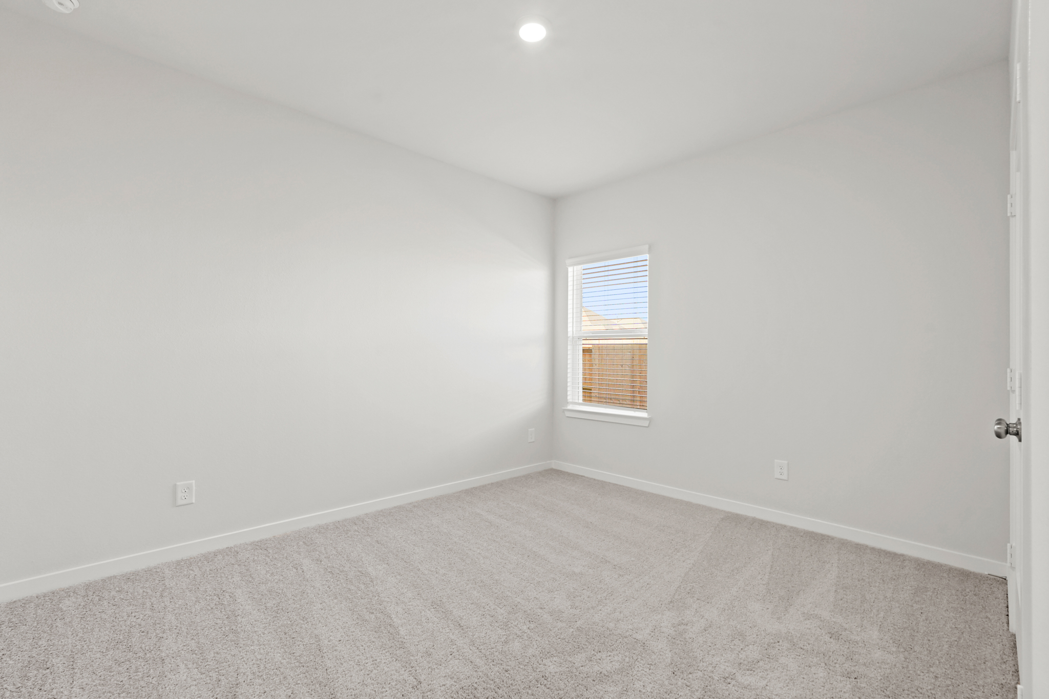 A room with a window and a carpet.