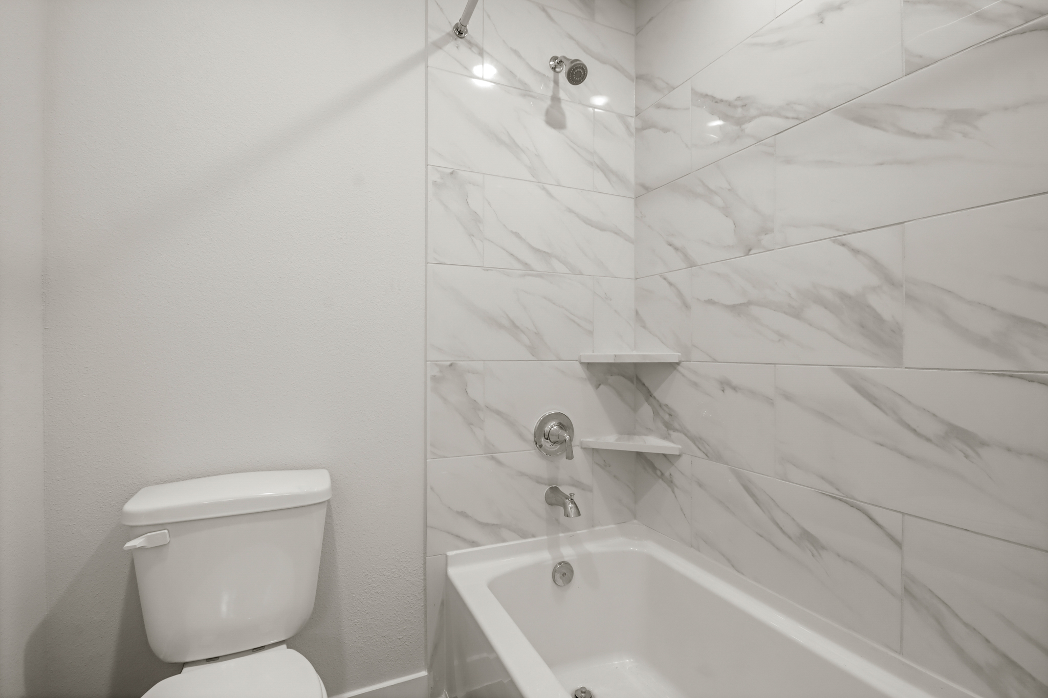 A bathroom with a shower and toilet.