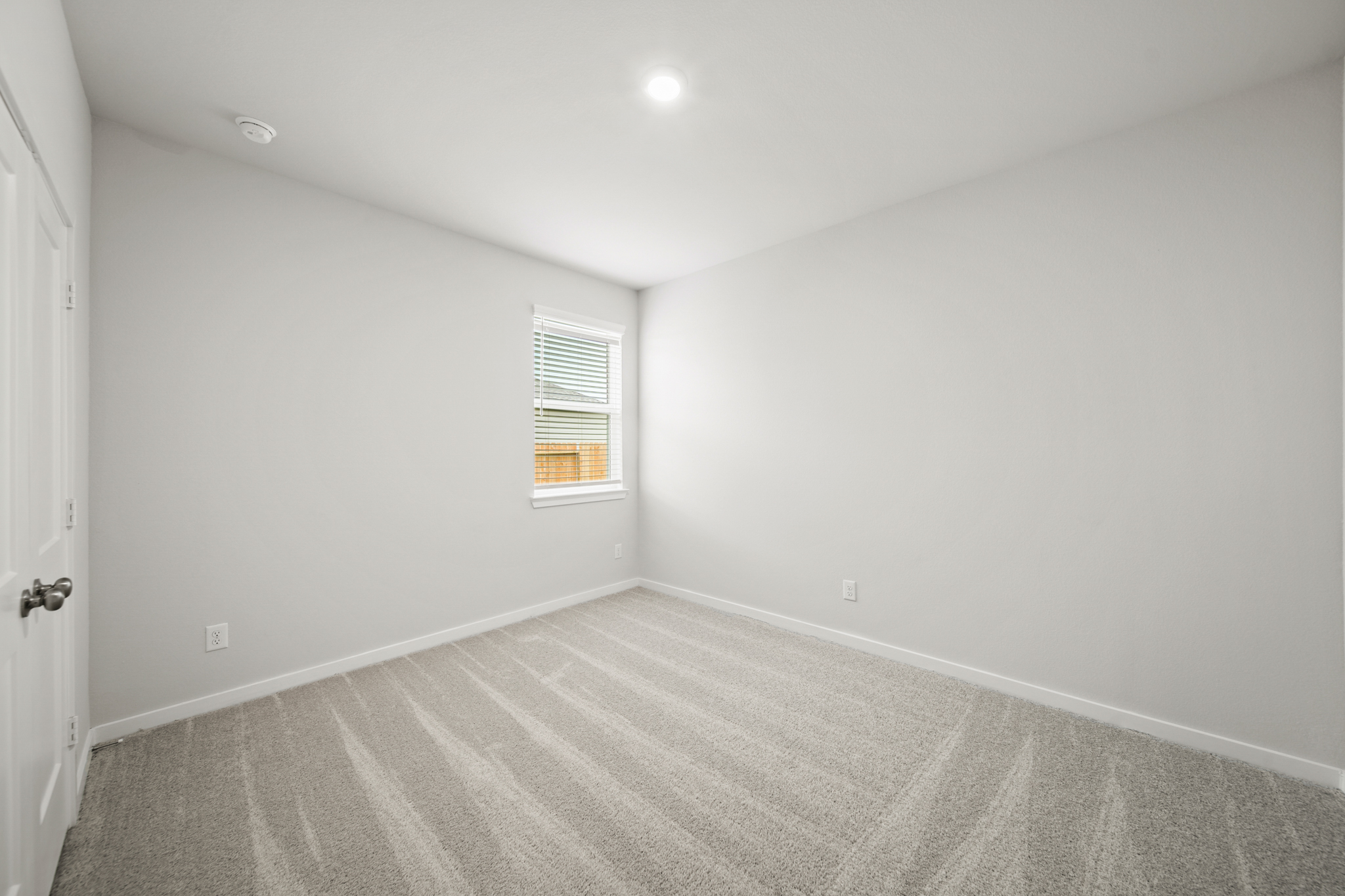 A room with a carpet and a window.