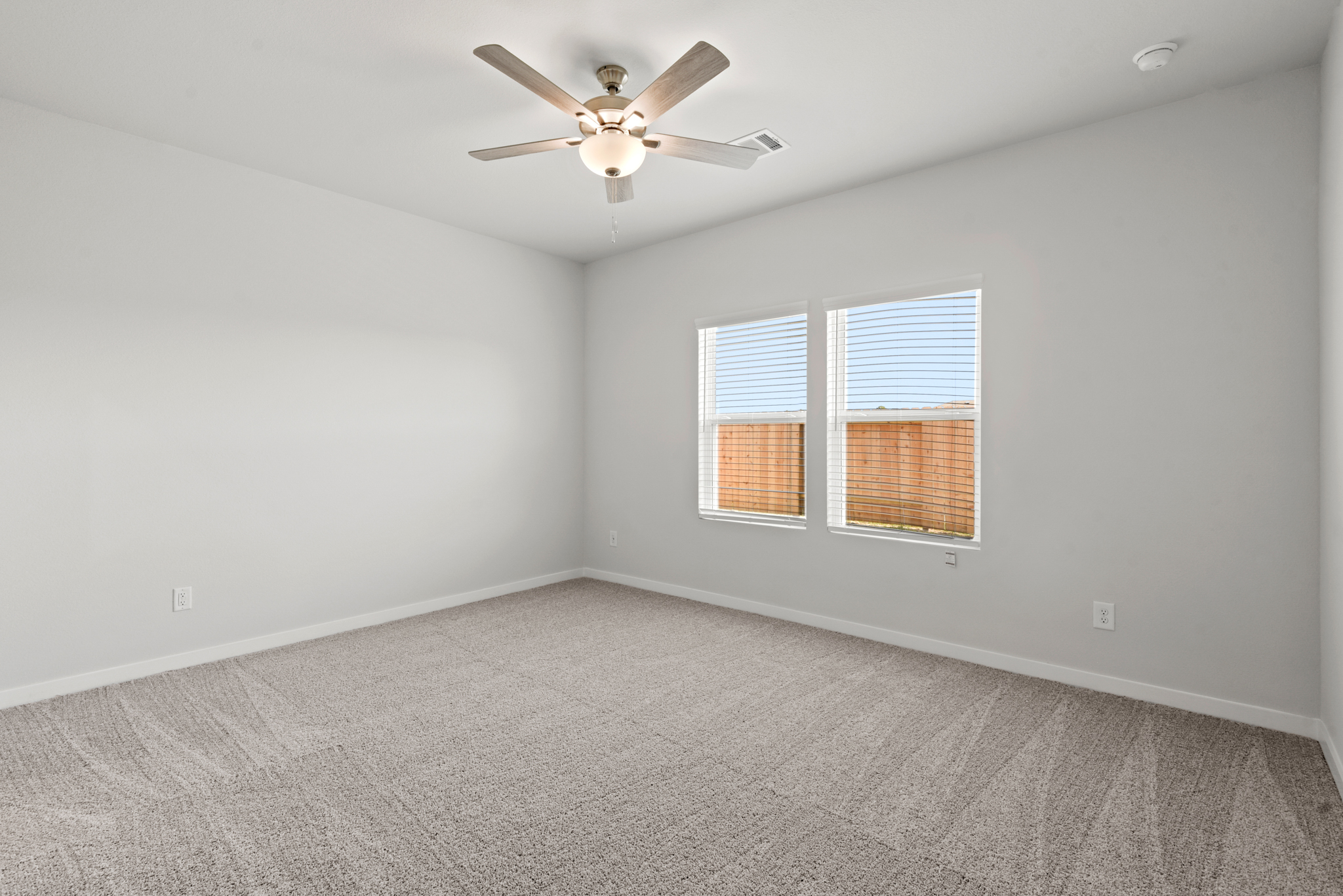 A room with a ceiling fan and a window.