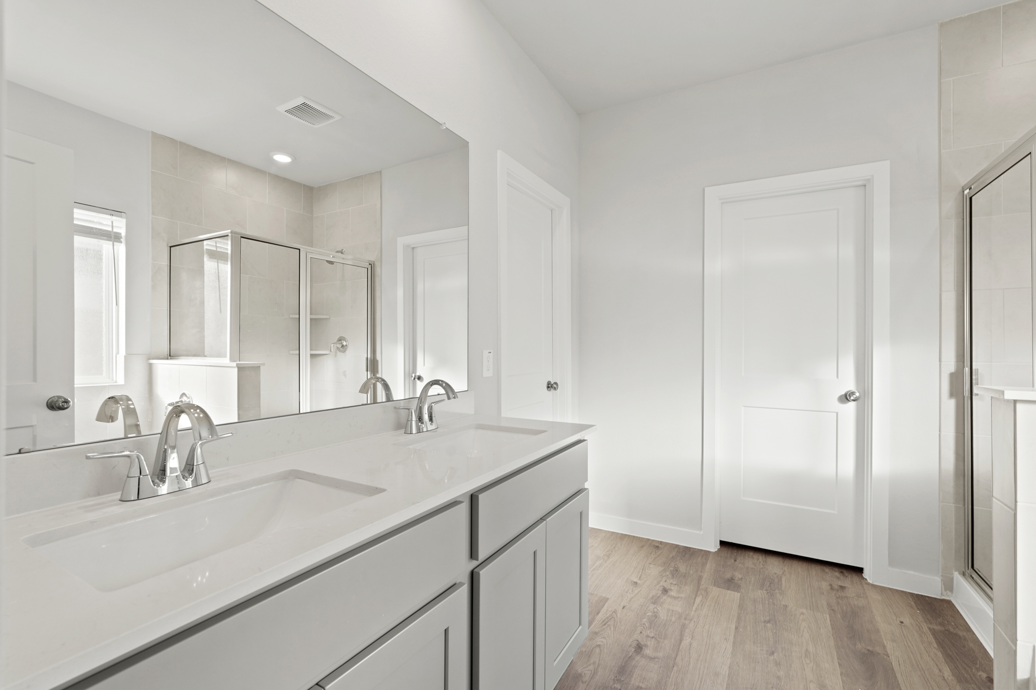 A bathroom with white cabinets.