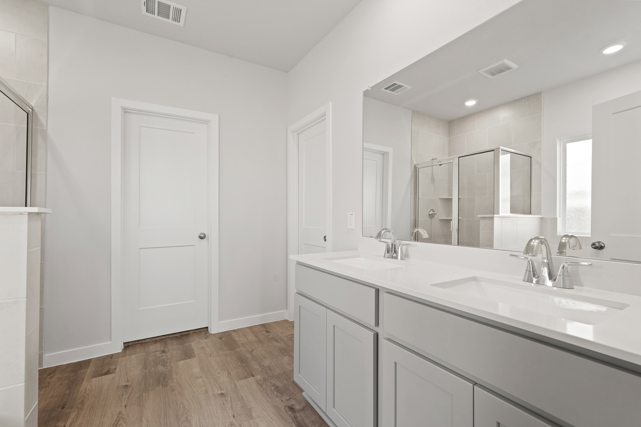 A bathroom with white cabinets.