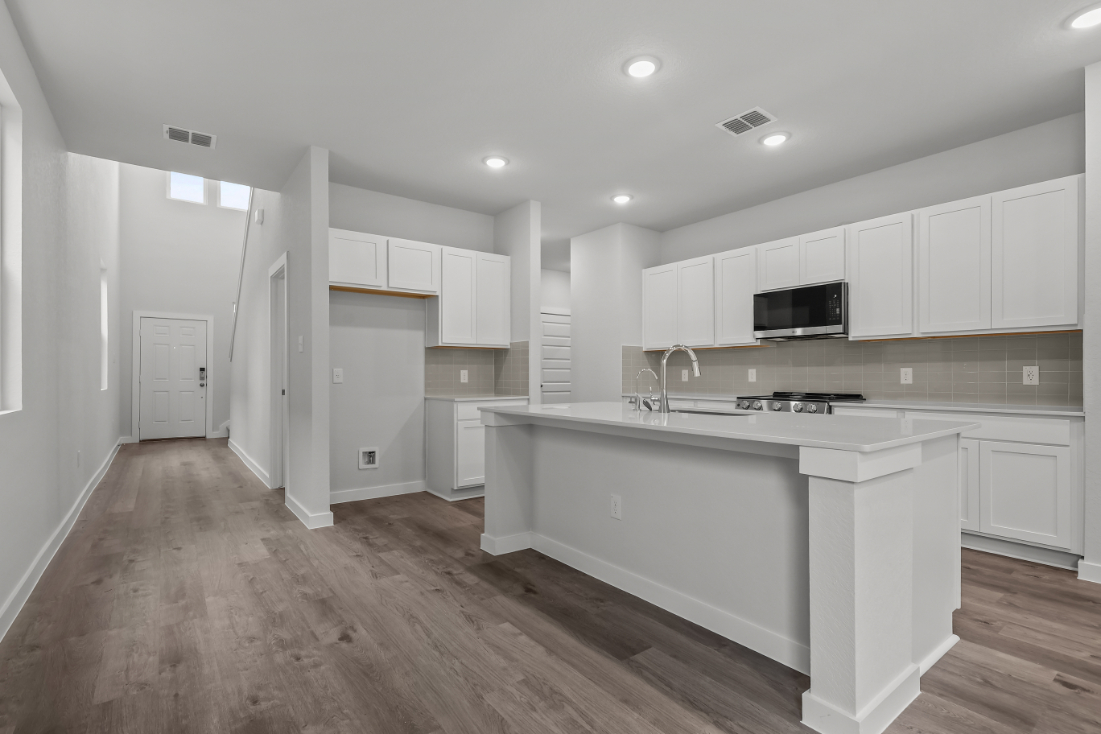 A kitchen with white cabinets.