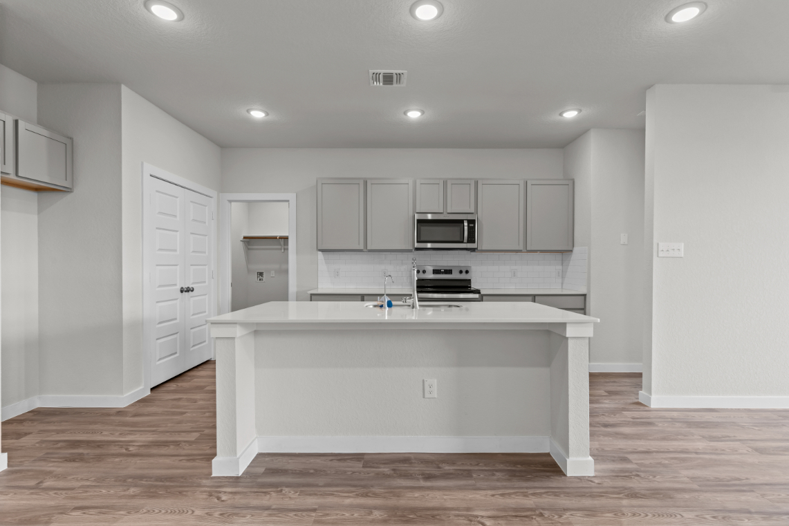 A kitchen with white cabinets.