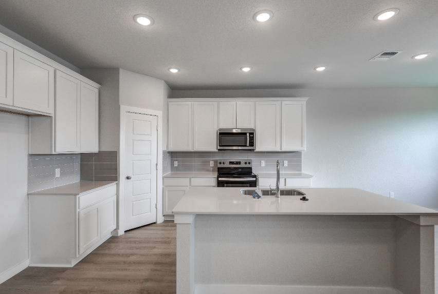 A kitchen with white cabinets.