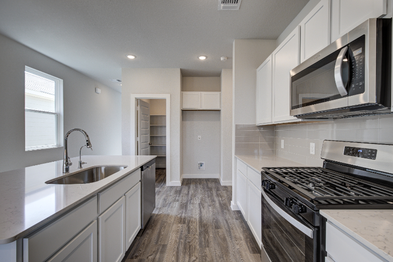 A kitchen with white cabinets.