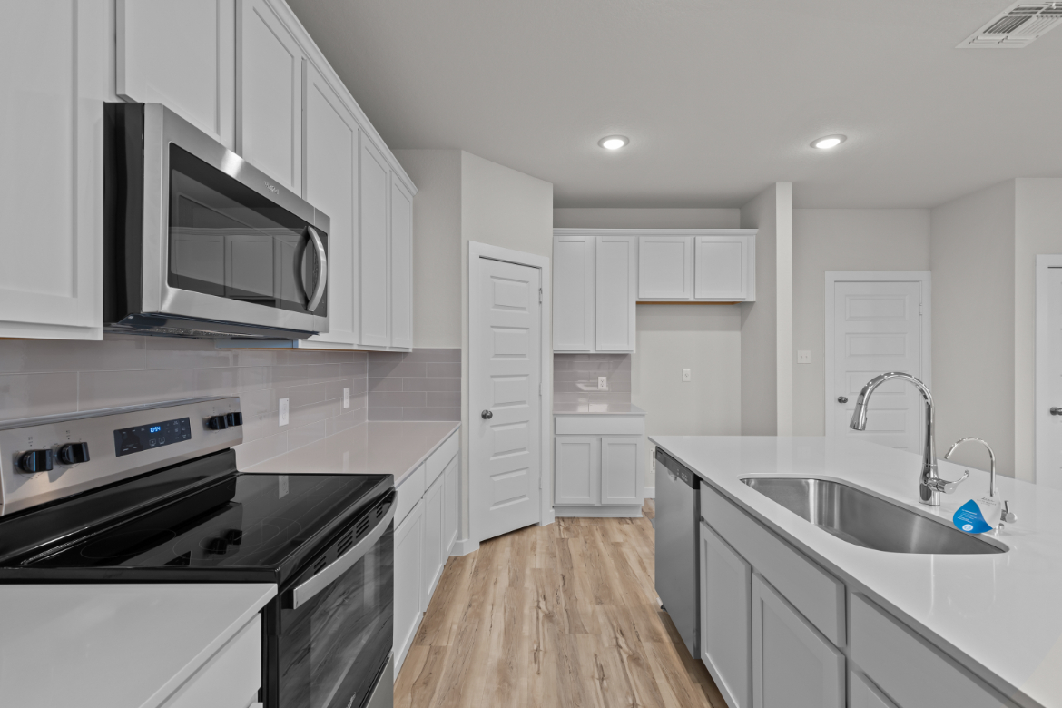 A kitchen with white cabinets.