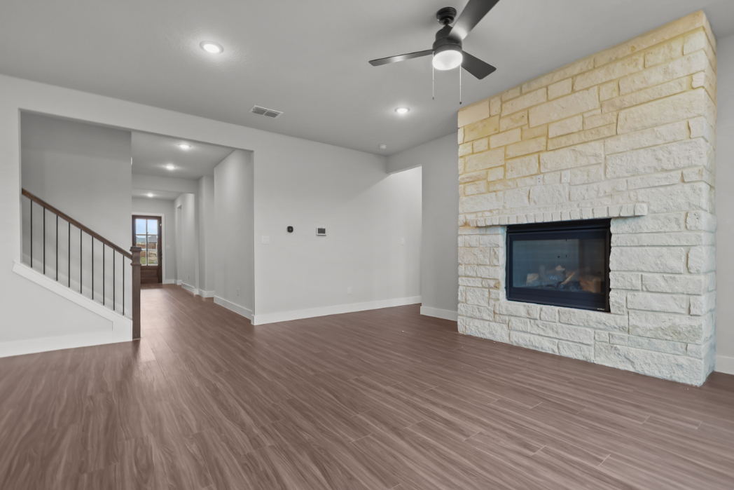 A room with a fireplace and a wood floor.