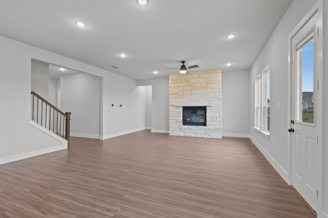 A room with a fireplace and wood floors.