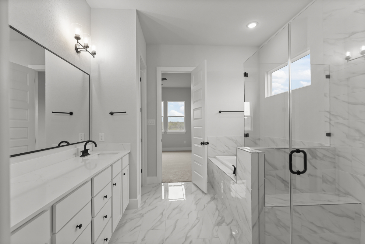 A bathroom with a shower unit and sink.