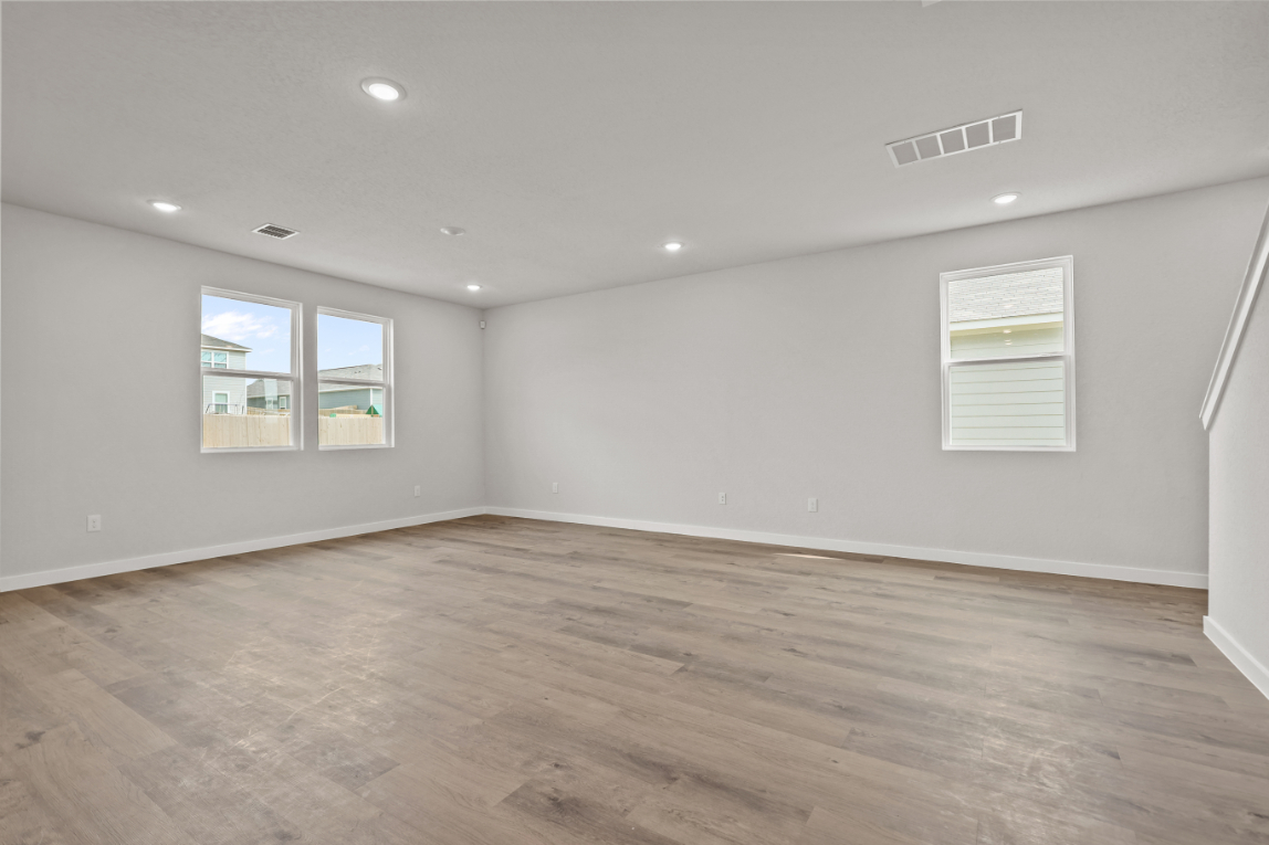 A room with a wood floor and a window.