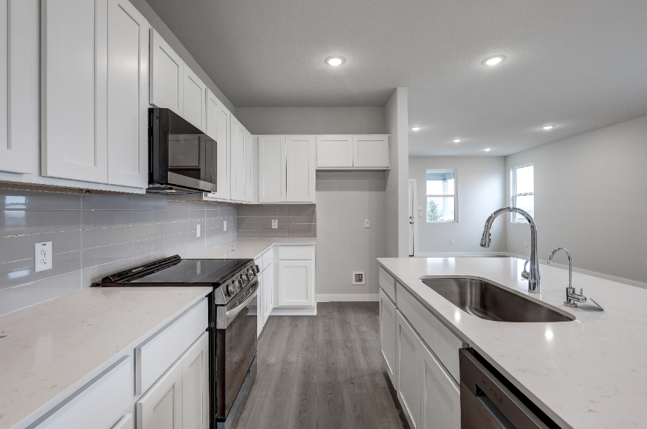 A kitchen with white cabinets.