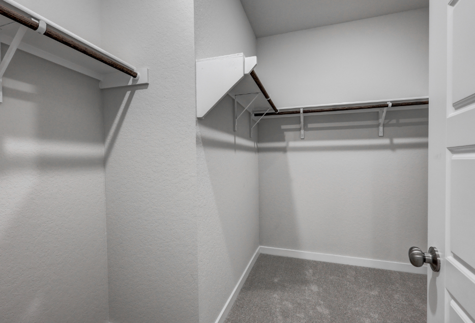 A white hallway with a metal railing.