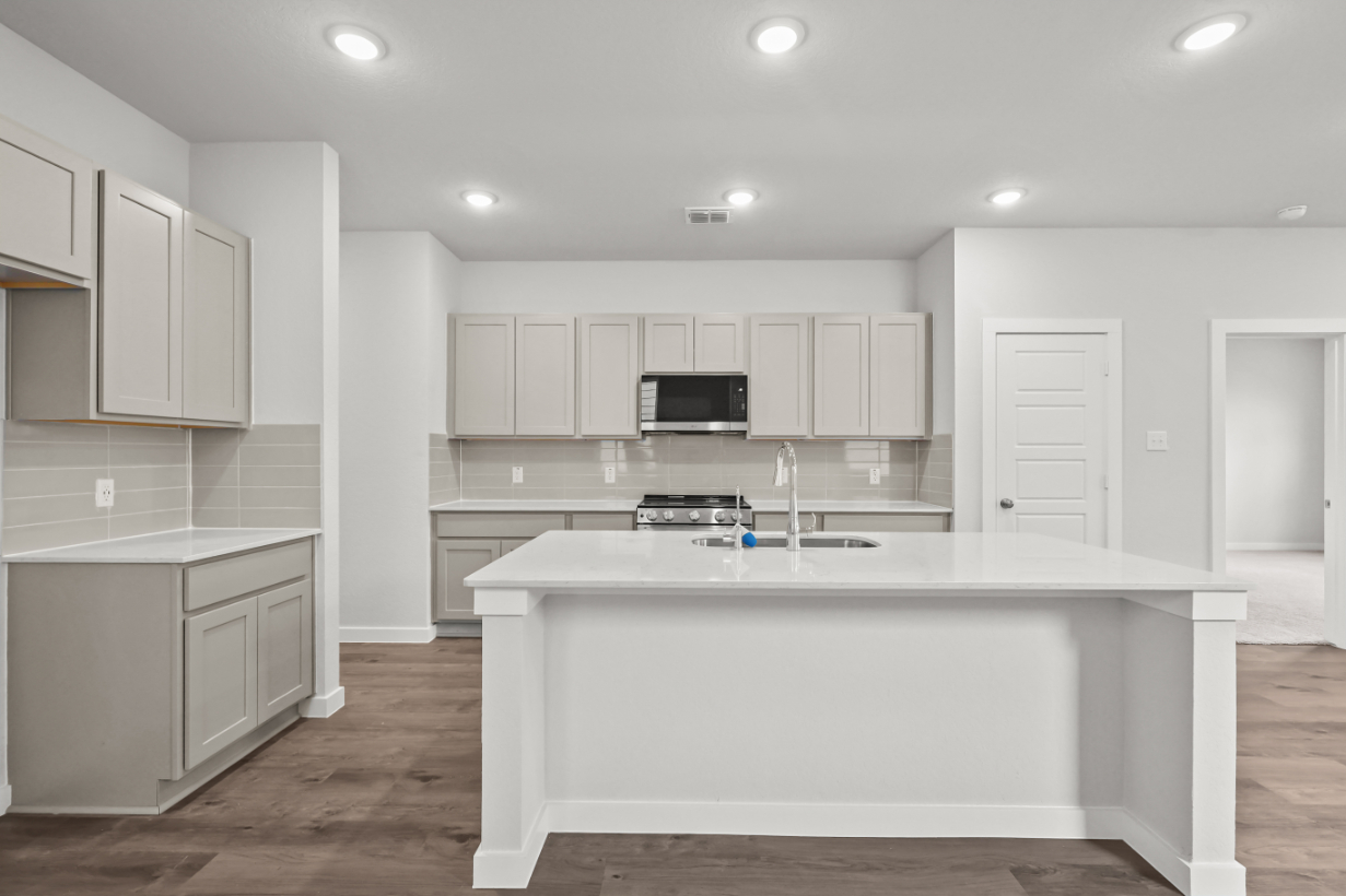 A kitchen with white cabinets.
