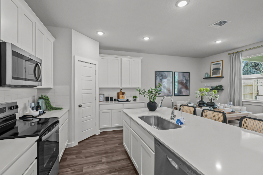 A kitchen with white cabinets.
