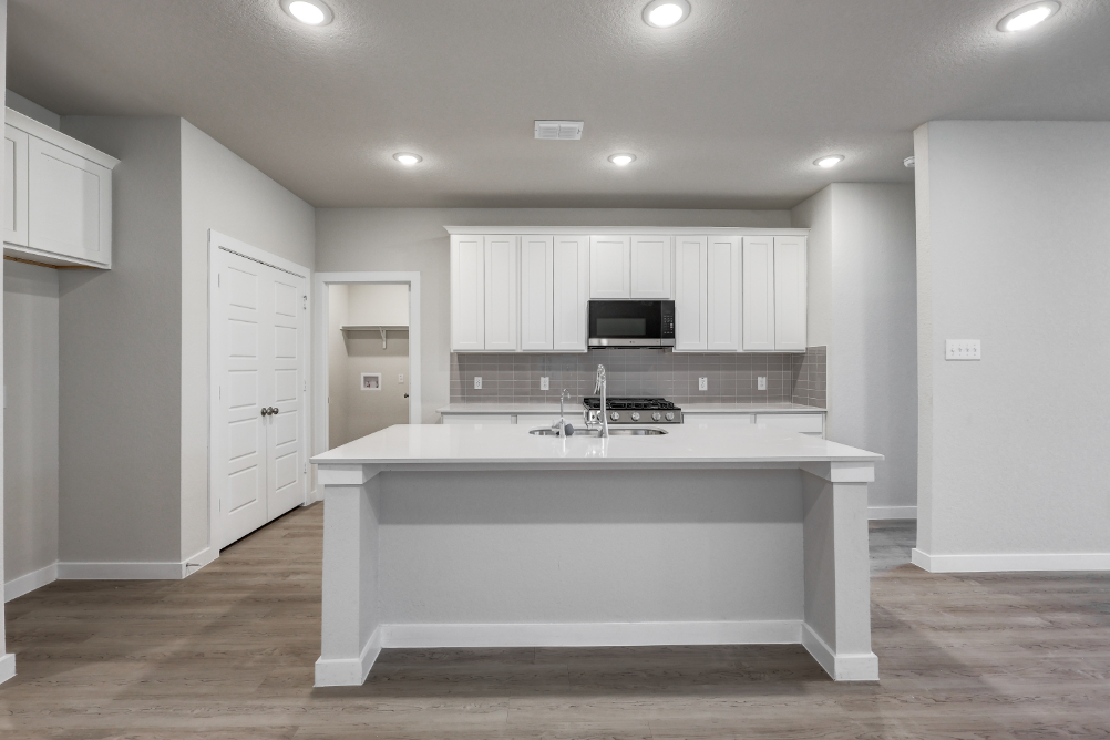 A kitchen with white cabinets.