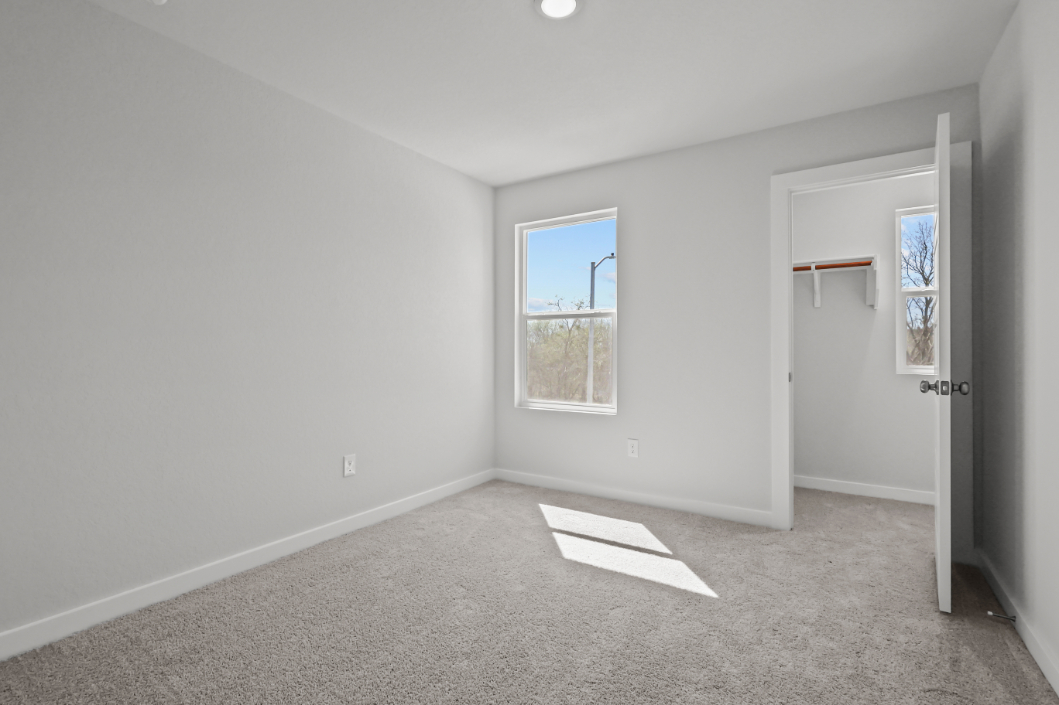 A room with a window and a rug in it.