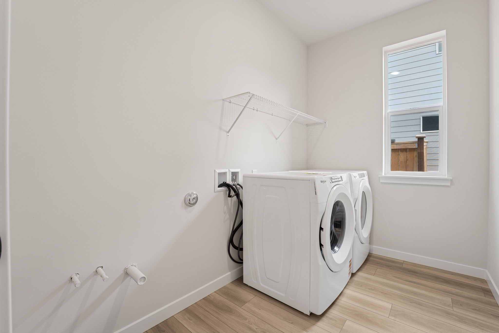 A white laundry room with a white laundry machine.