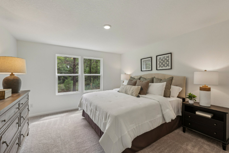 A bedroom with a bed and lamps.